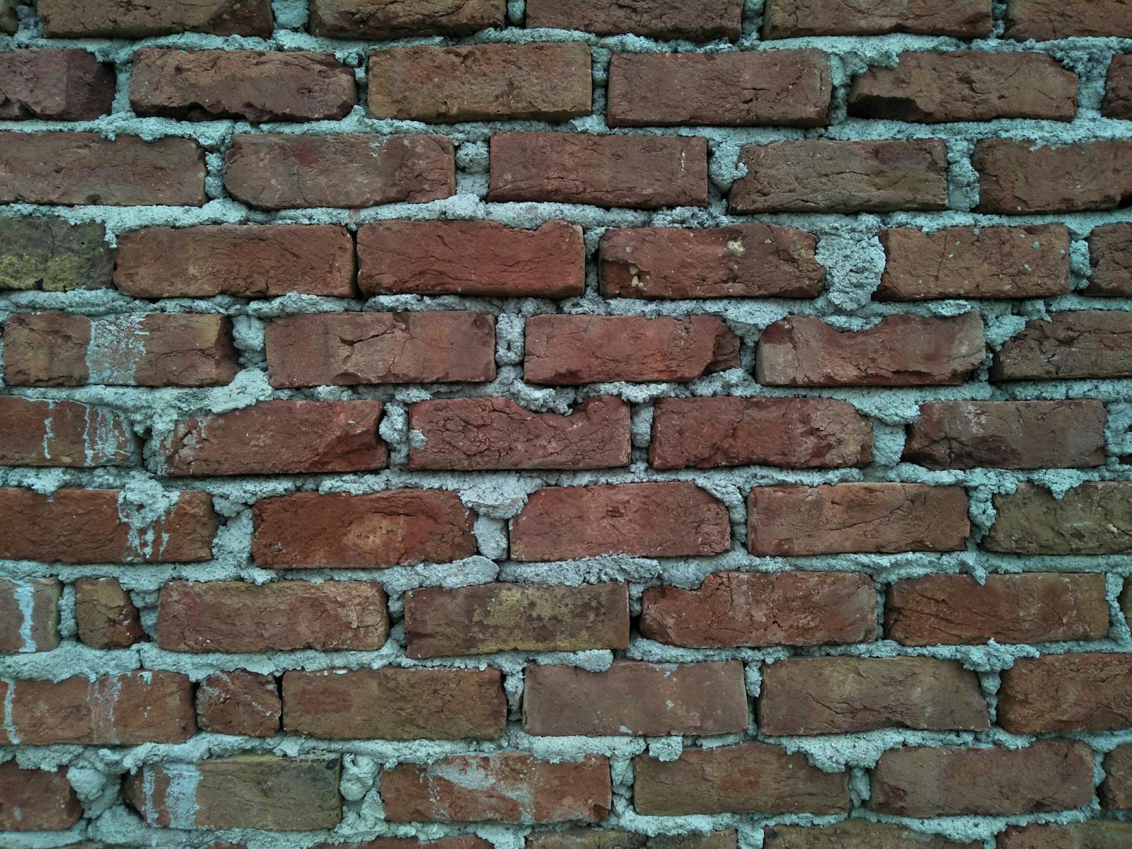 Weathered brick wall with deteriorating mortar before repair