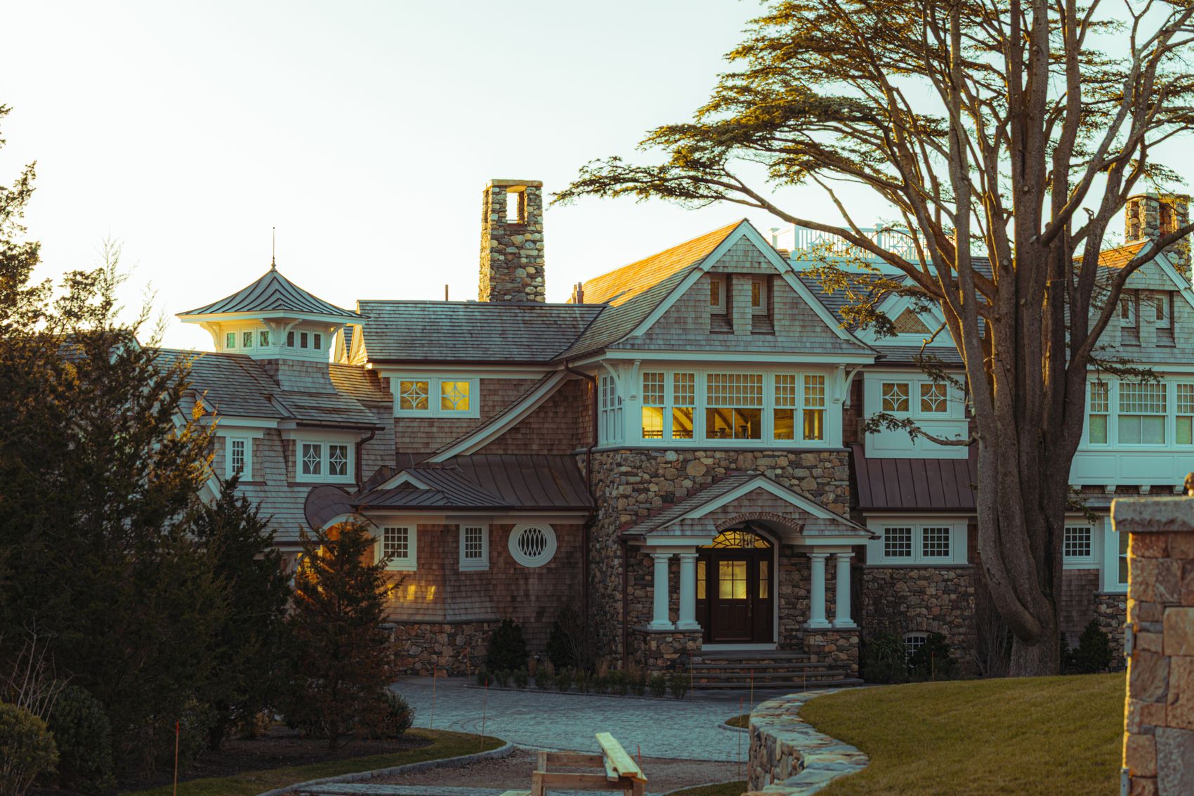 Stone-and-shingle home with hand-laid stone facade and chimney